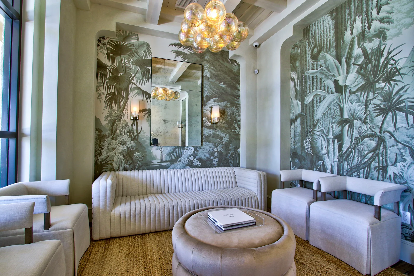 Bright Ennis Plastic Surgery lounge with botanical wallpaper, sculptural brass lighting and cream sofas
